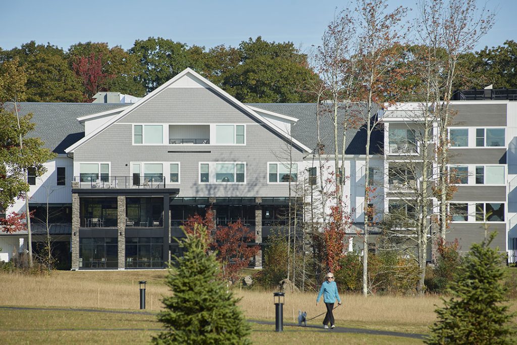 The shingle-style building exteriors echo the familiar local New England building materials but with a simplified contemporary feel created by flat roofs and storefront and corner windows.